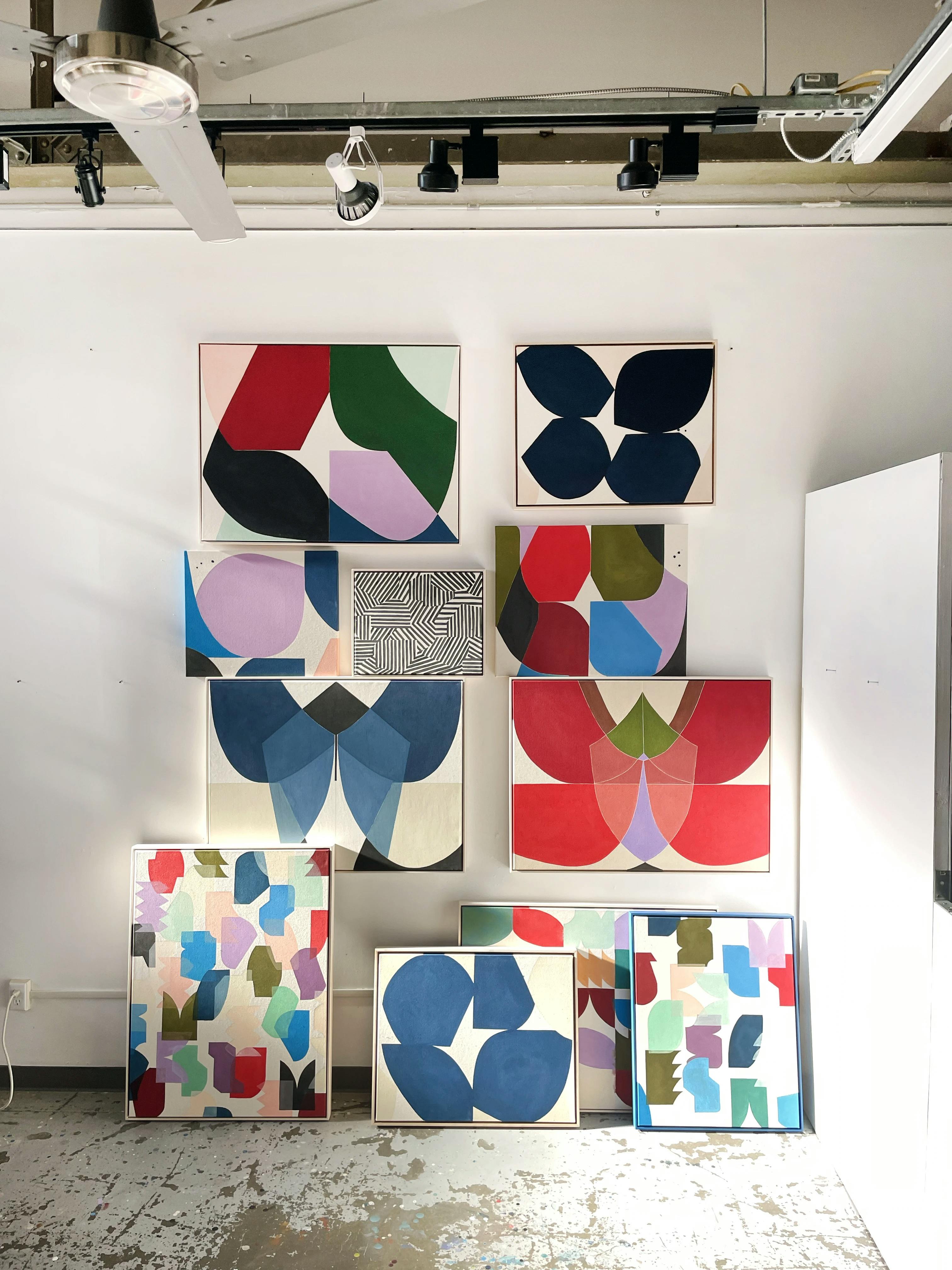 A collection of large, multicolored abstract paintings by artist Christina Flowers in her studio.
