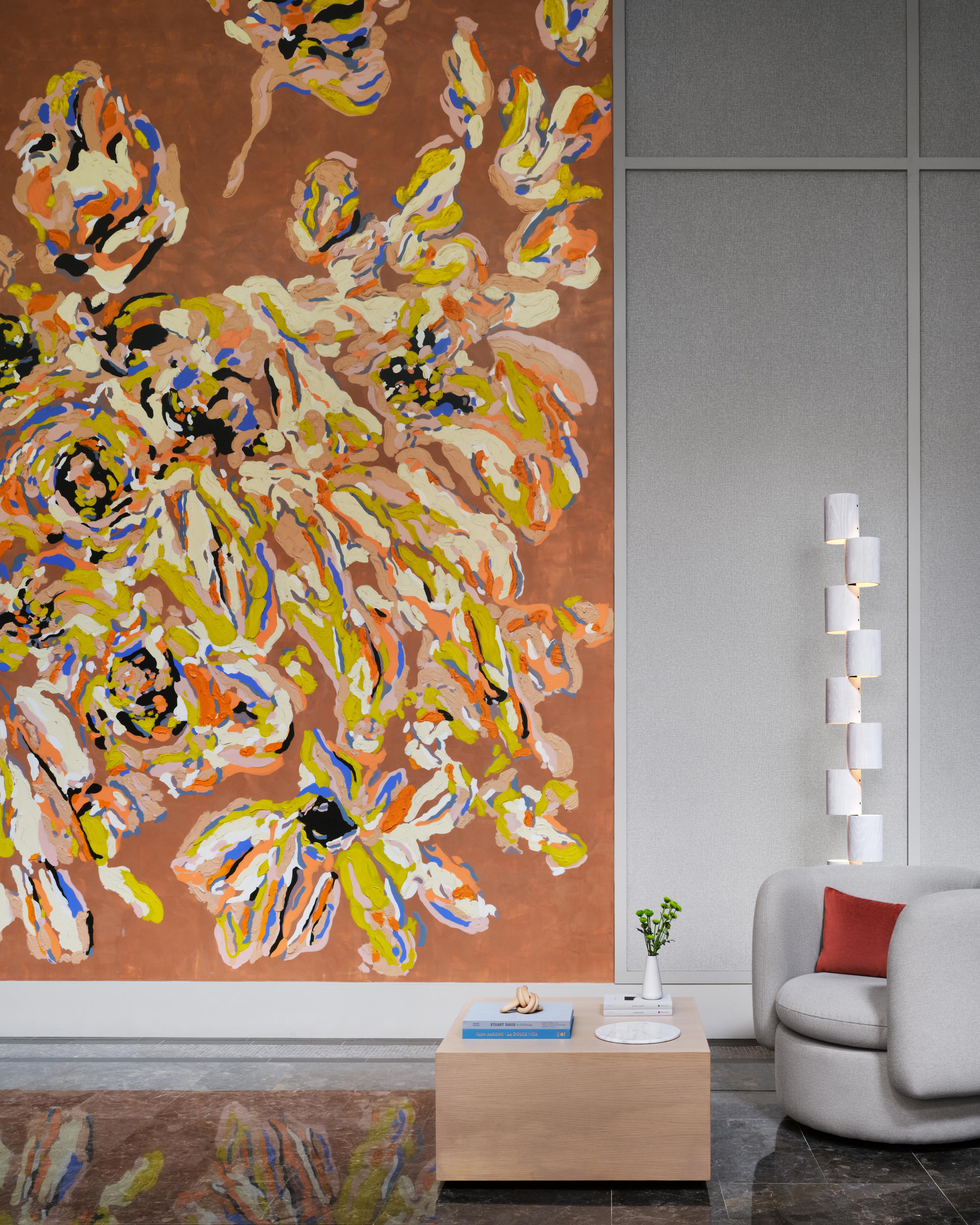 A orange, floral wall mural by artist Erin Lynn Welsh within the lobby area of Anagram NoMad.