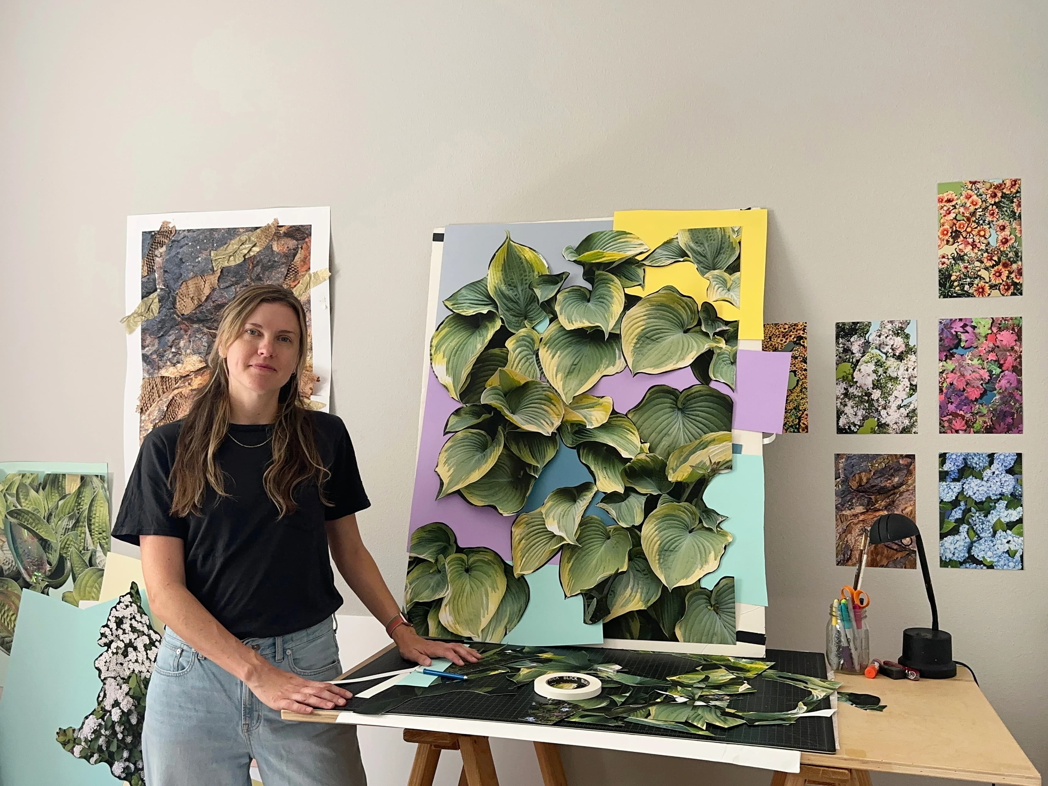 Artist Teresa Christiansen standing in her studio next to collage-based artwork of leaves.