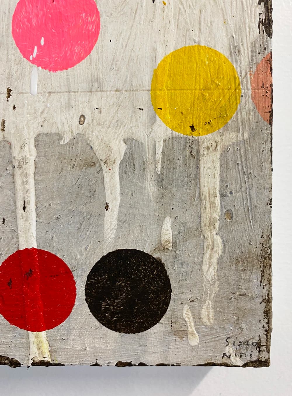 A close-up of colored circles on a distressed canvas by artist Susan Simonini.