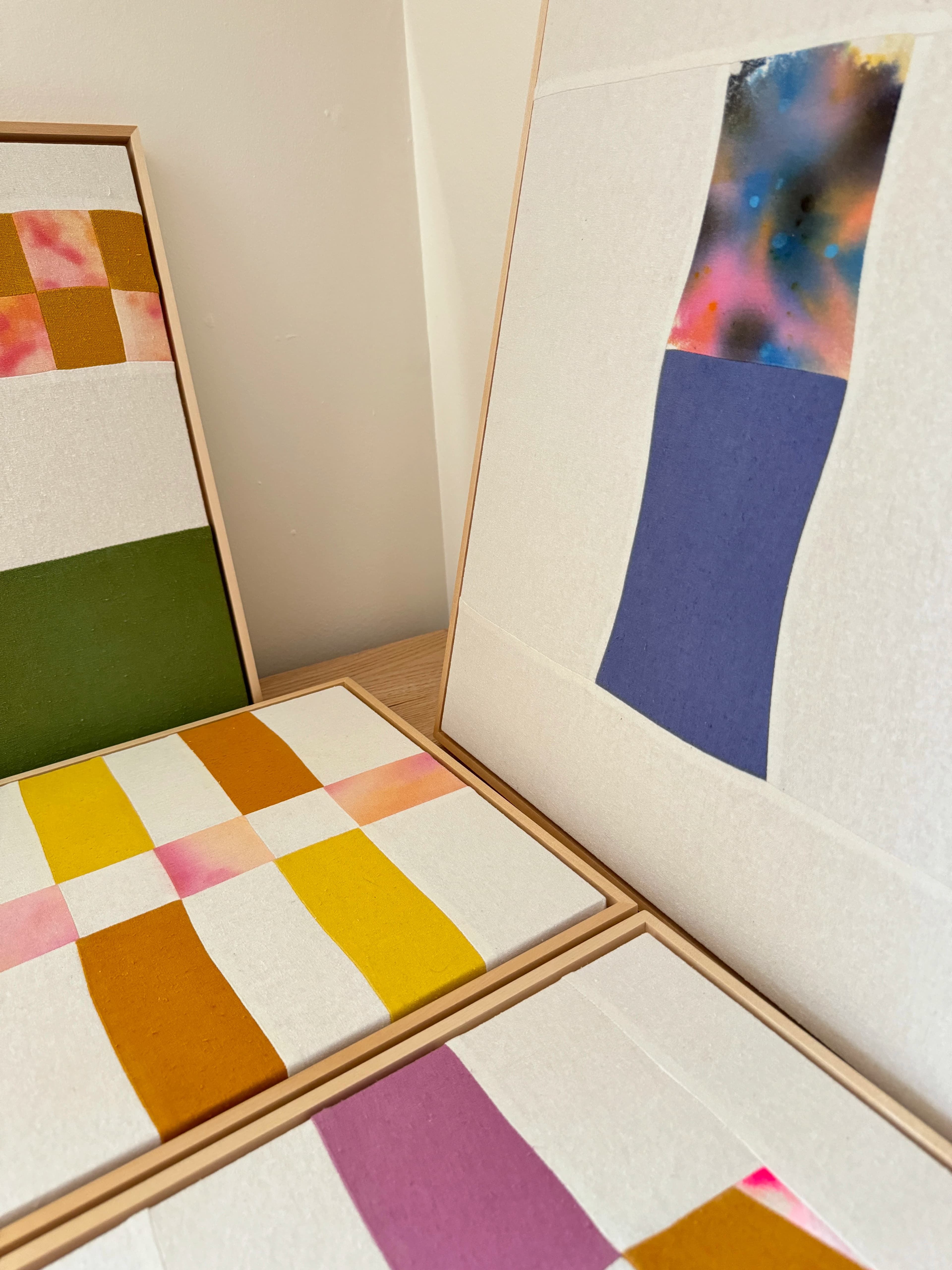 Framed, multicolored textile patchwork pieces by artist Anastasia Greer in her studio.