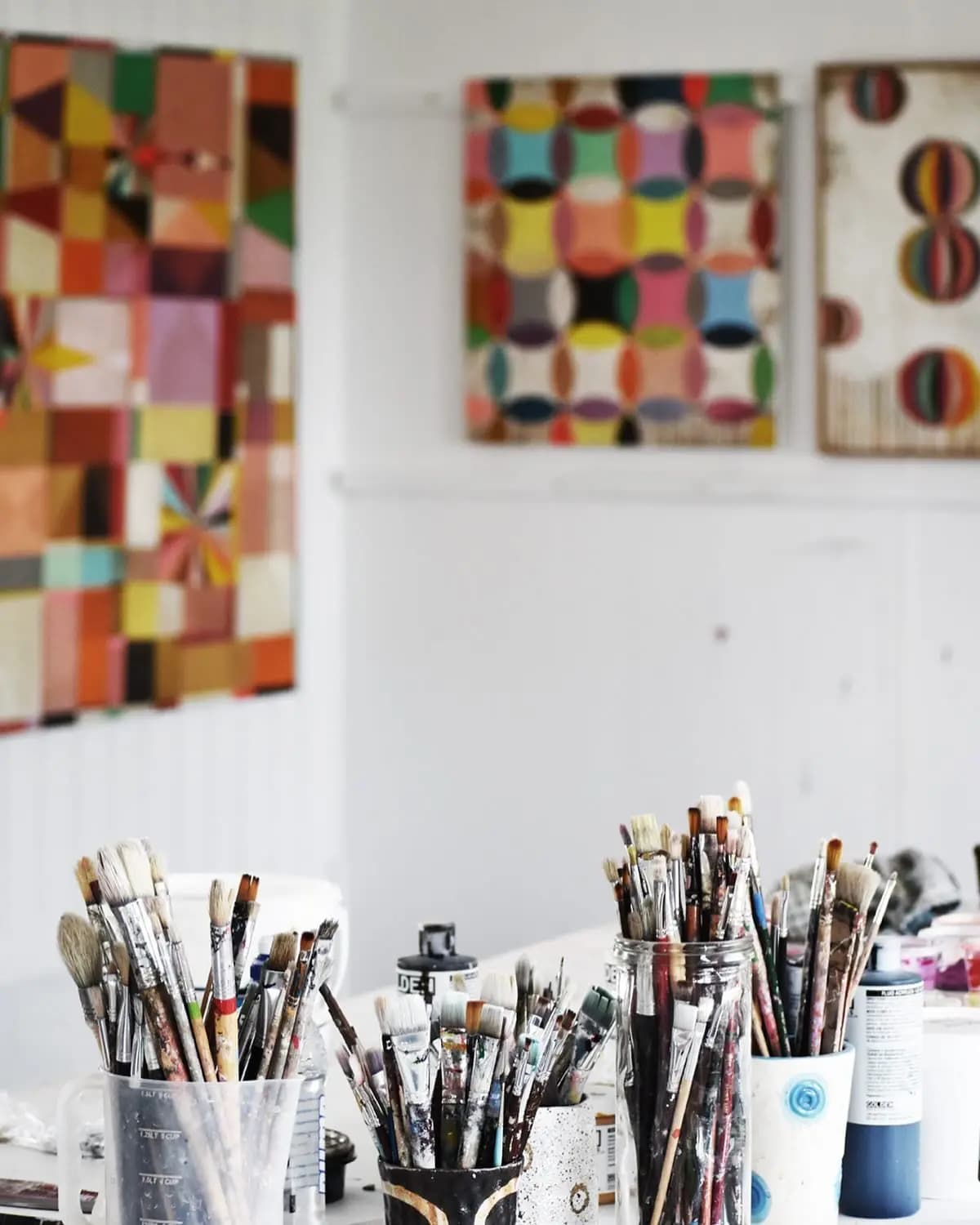 Paintings and cups full of brushes in artist Susan Simonini's Tasmanian studio.