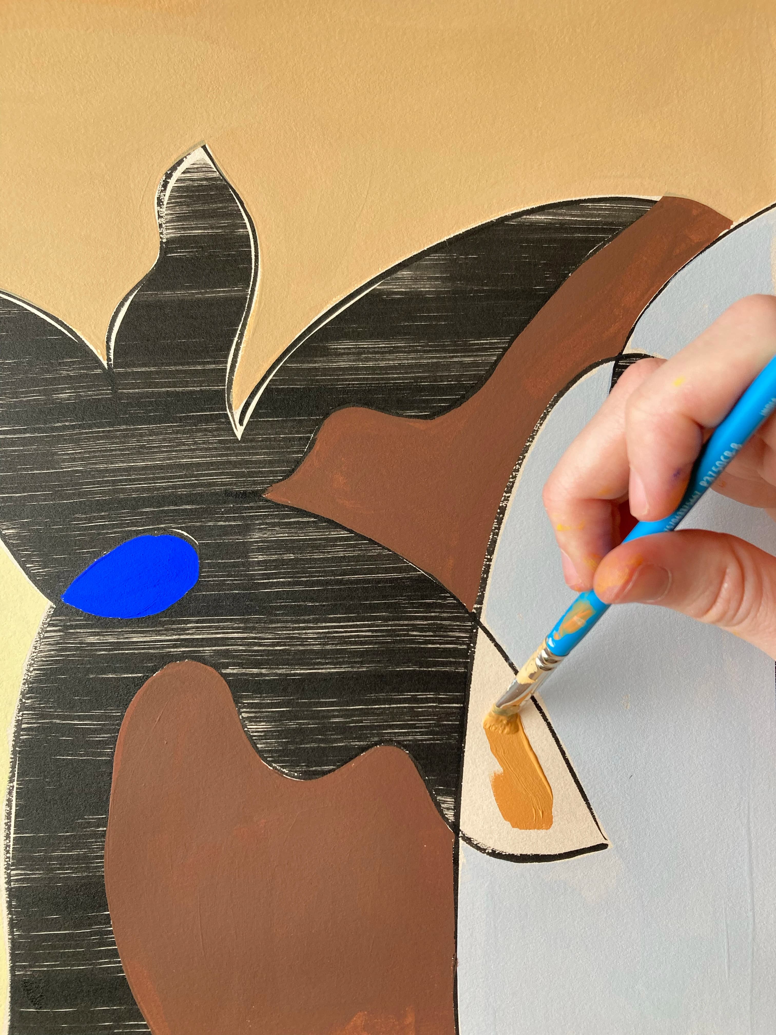 A close-up of artist Anna Koeferl painting an orange leaf.