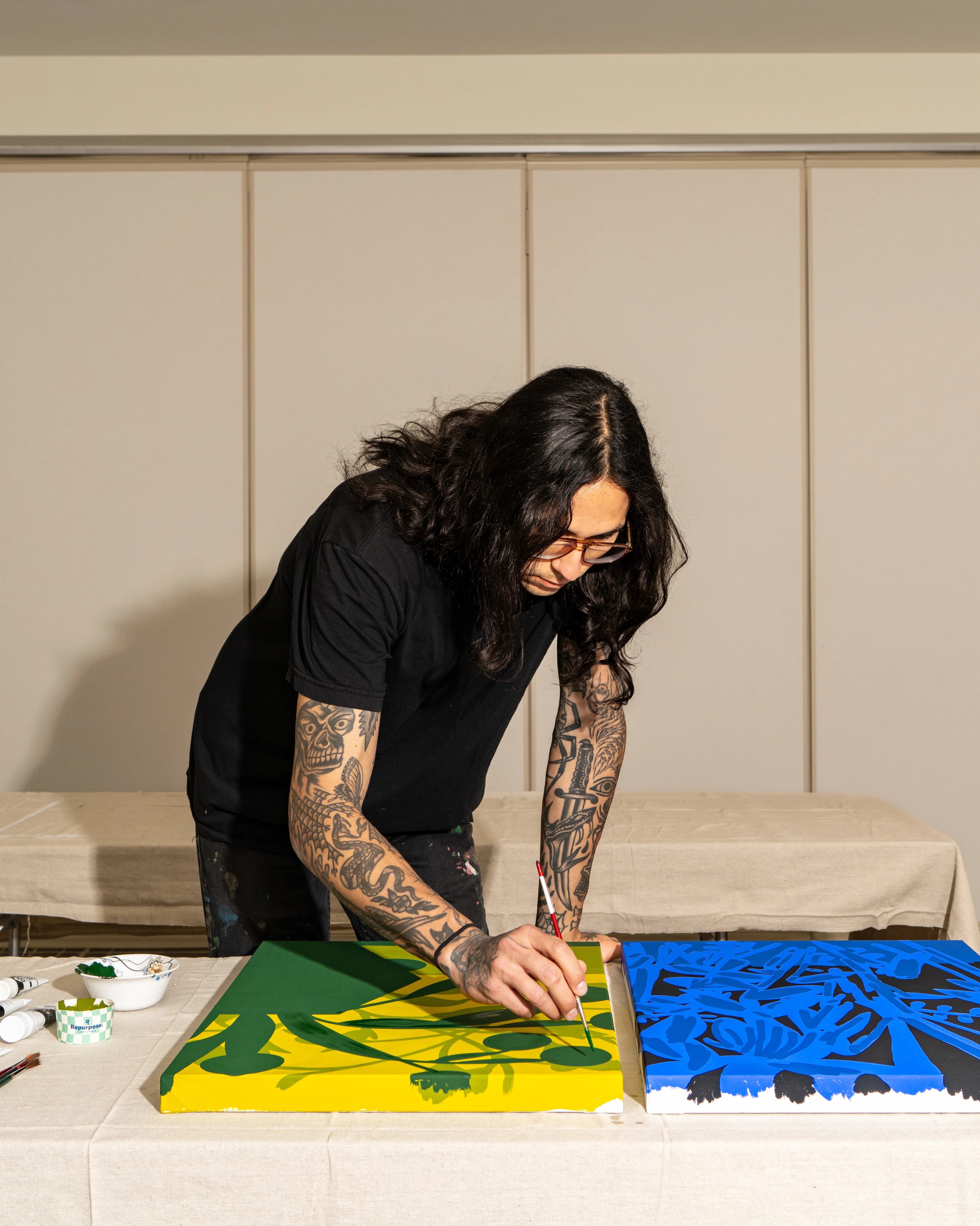 Artist Eddie Perrote painting abstract, botanical works in a studio during his Uprise Art x MacArthur Place Residency.