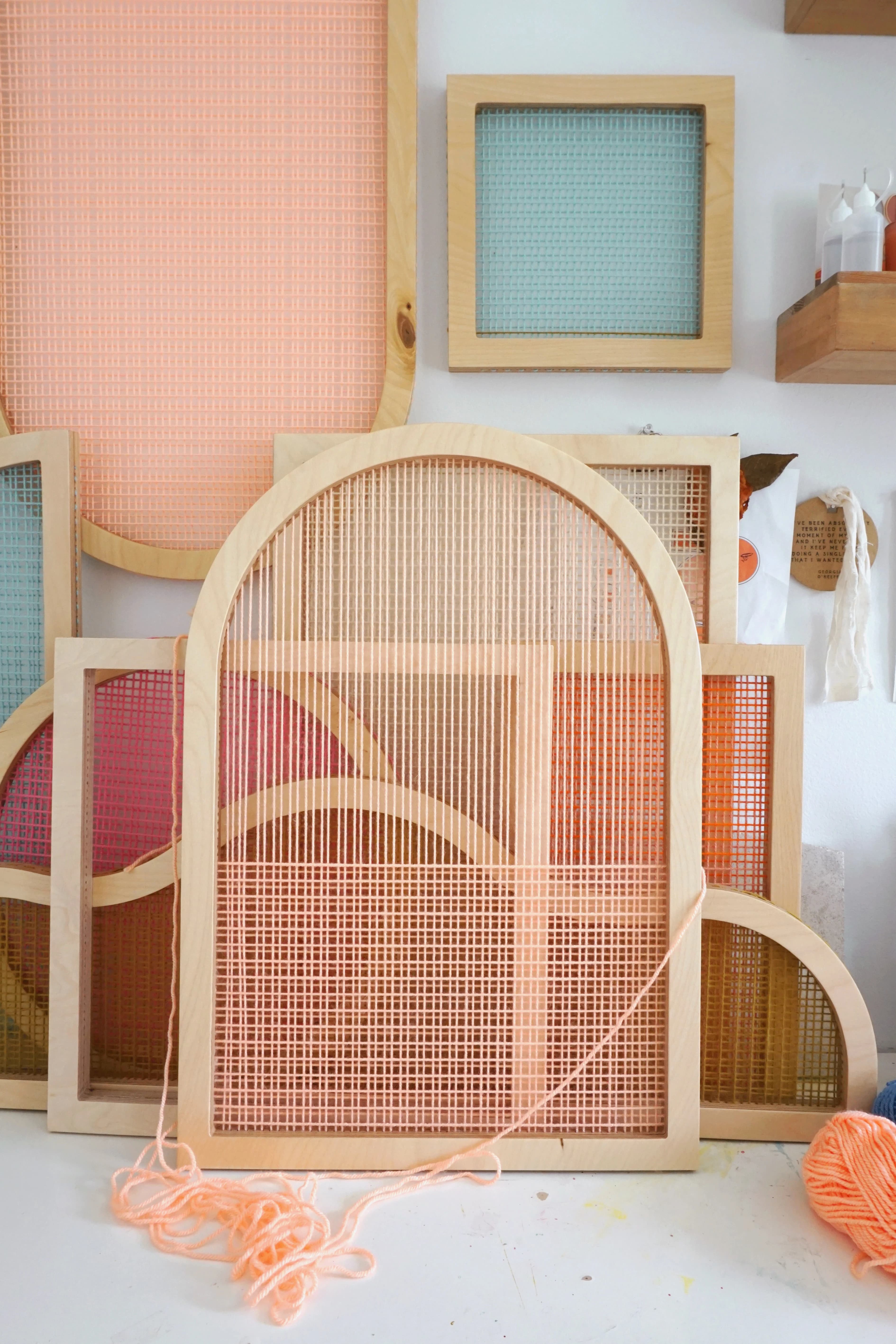 An in-progress arched shaped screen made from pale pink yarn in artist Hayley Sheldon's studio.