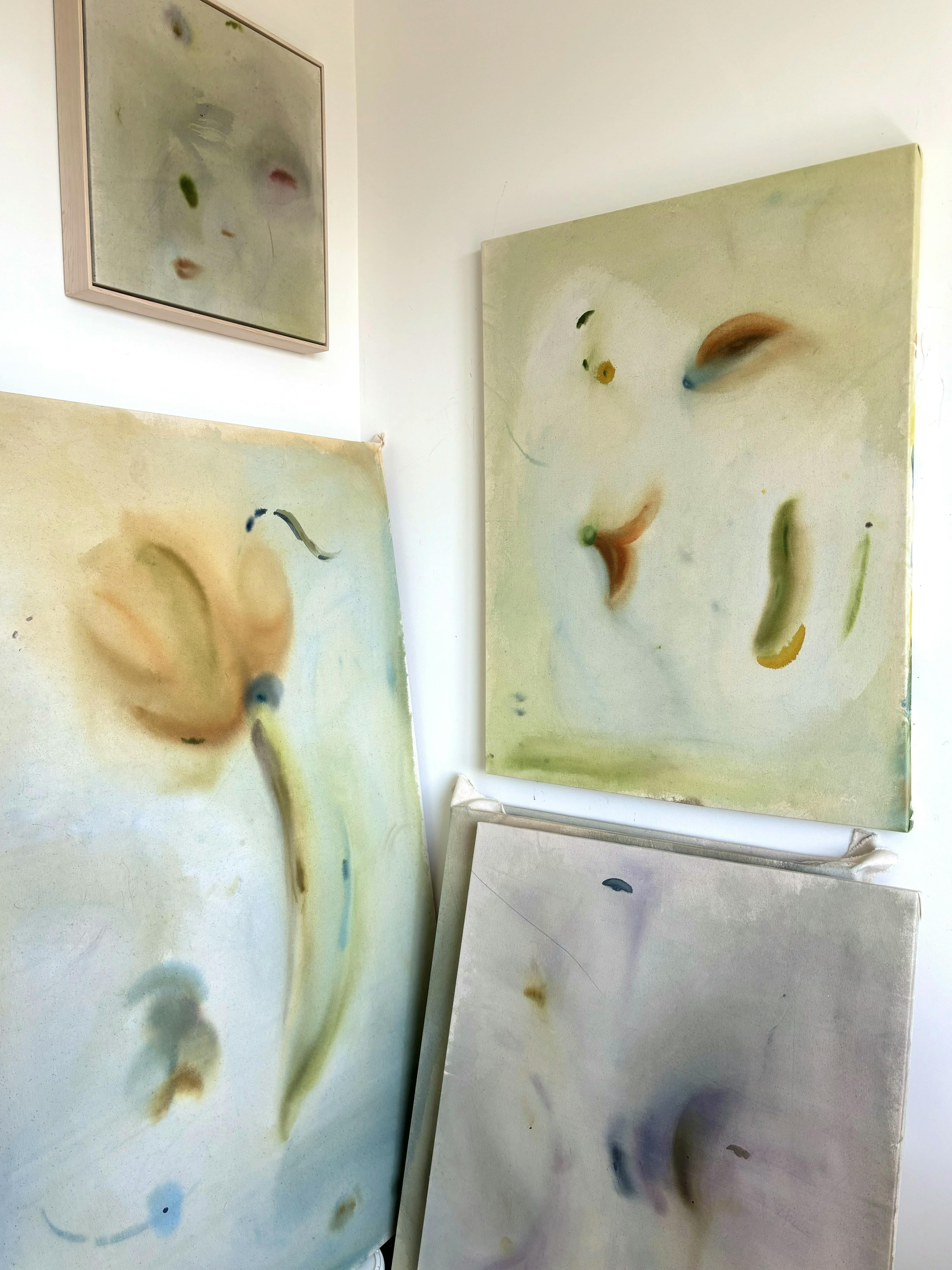 Soft, abstract gestural paintings on canvas by artist Arlina Cai in her studio.