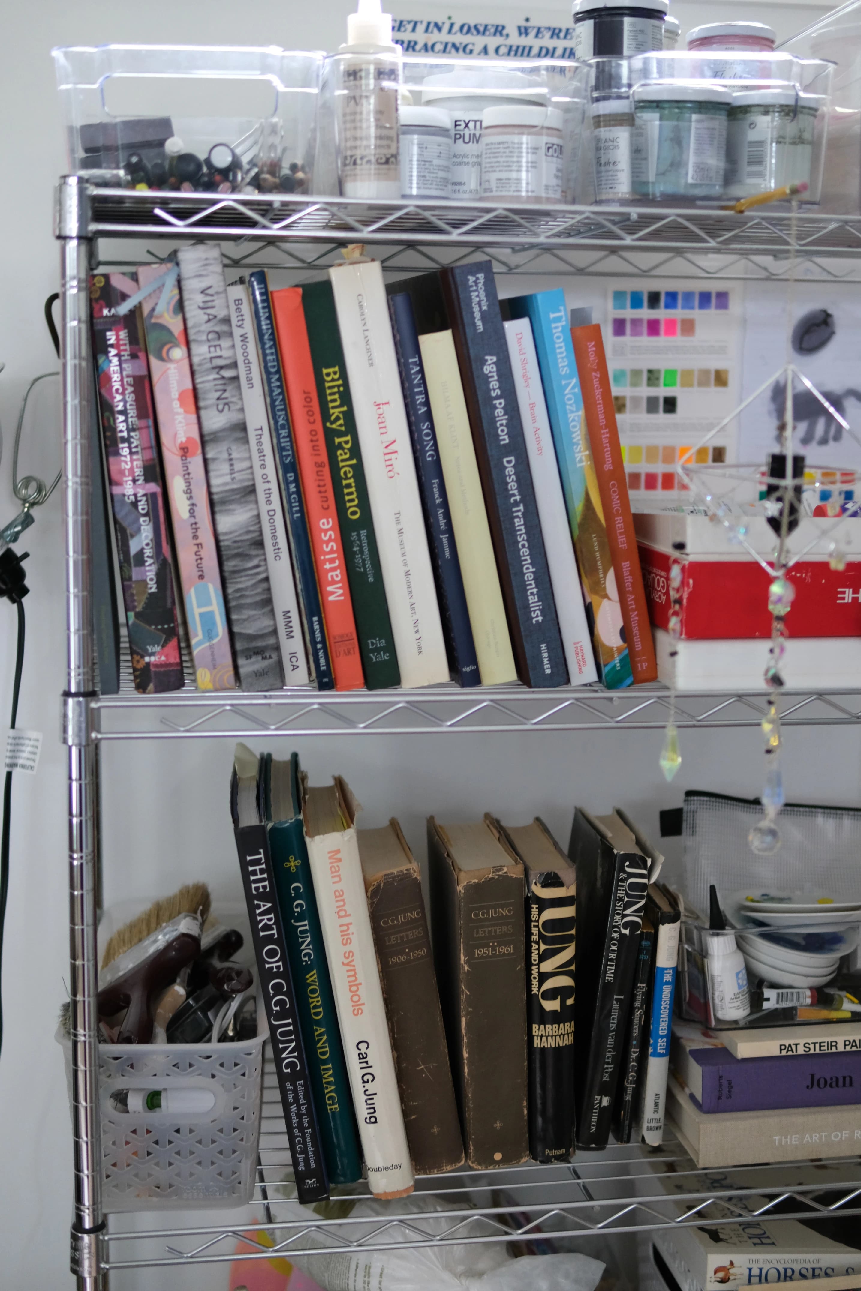 Books on a shelf in artist Ashely Peifer's studio. 