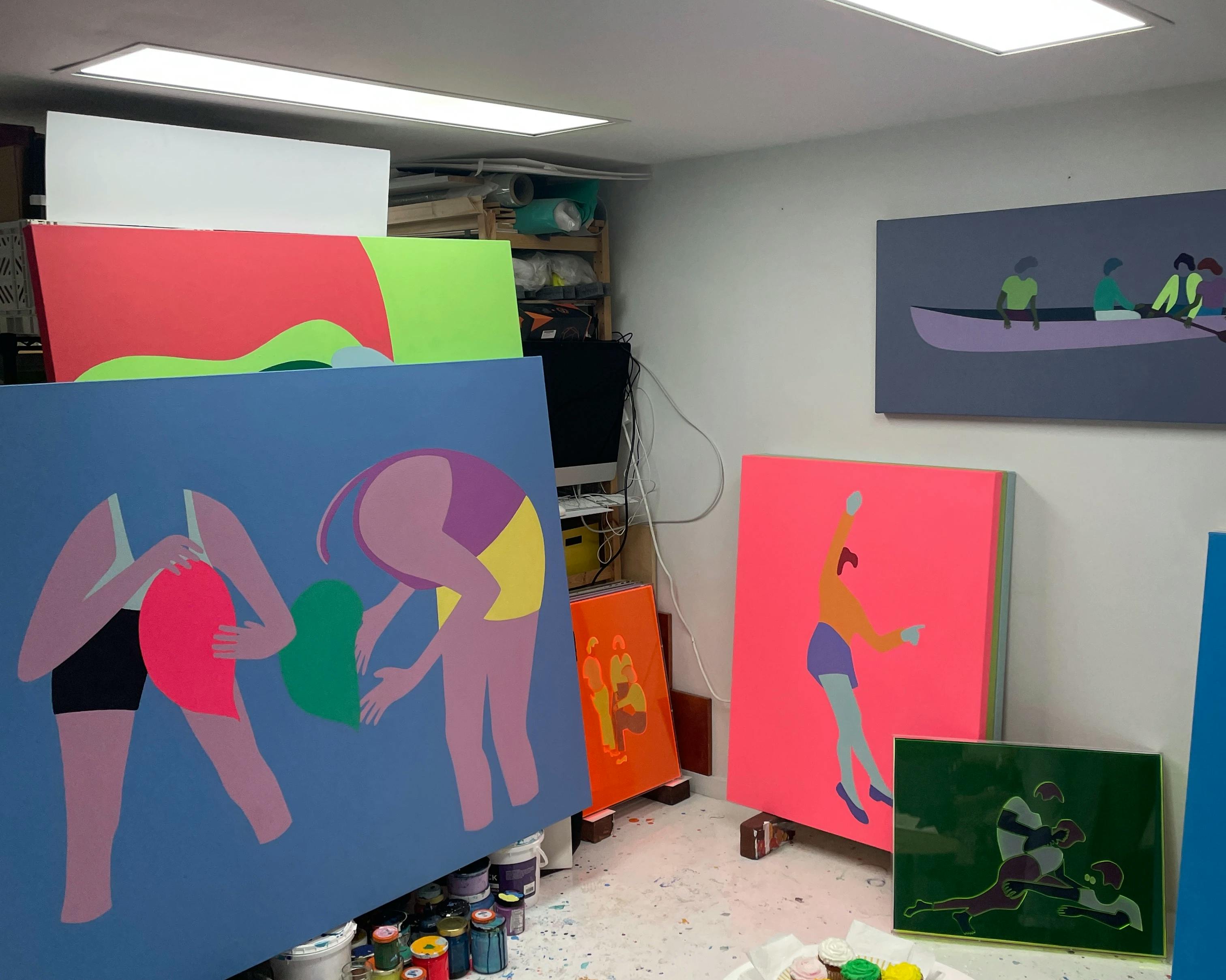 Colorful, figurative paintings on canvas in artist Dana Bell's studio.