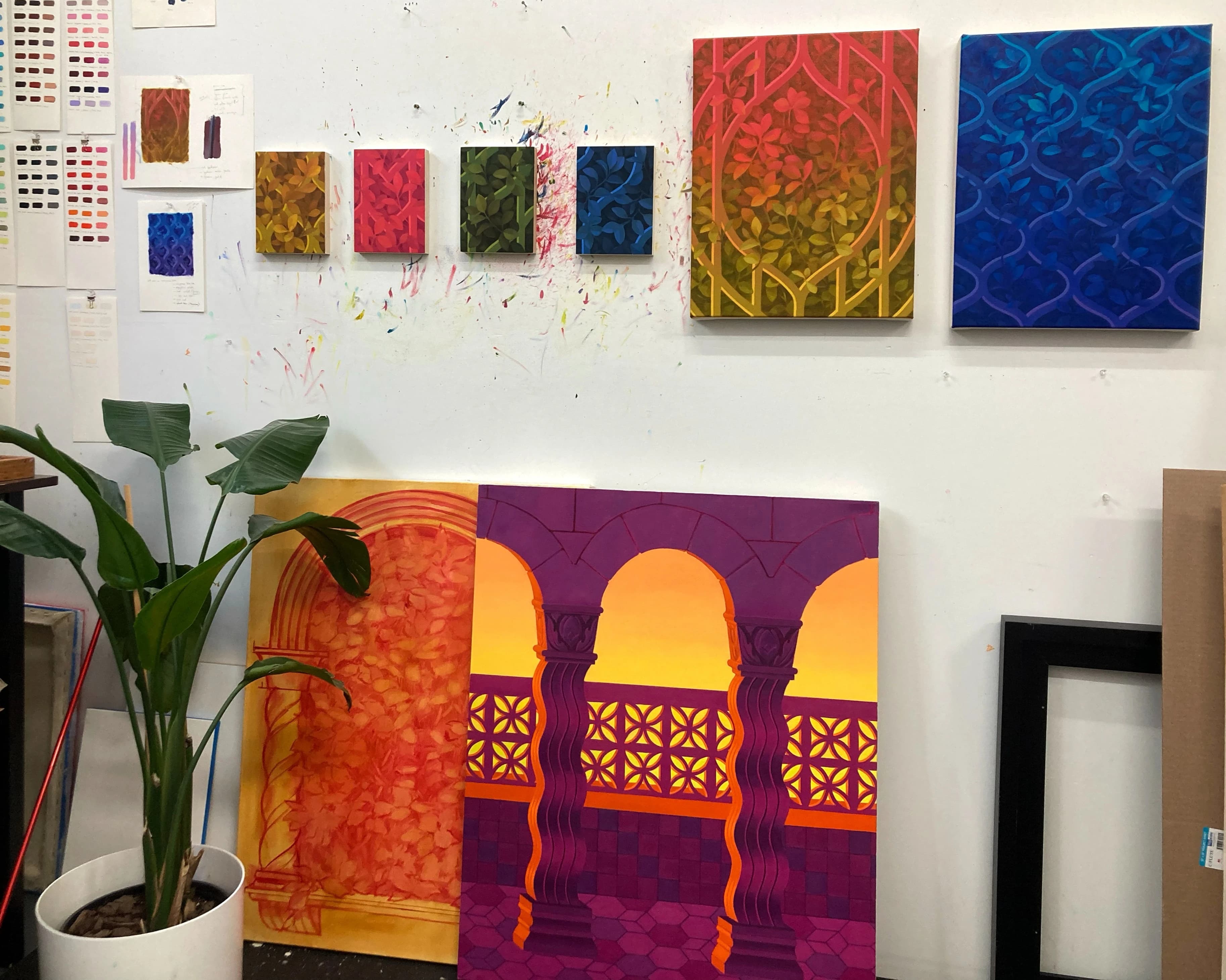 Colorful, architectural paintings against a white wall in the studio of artist Lucía Rodríguez Pérez.