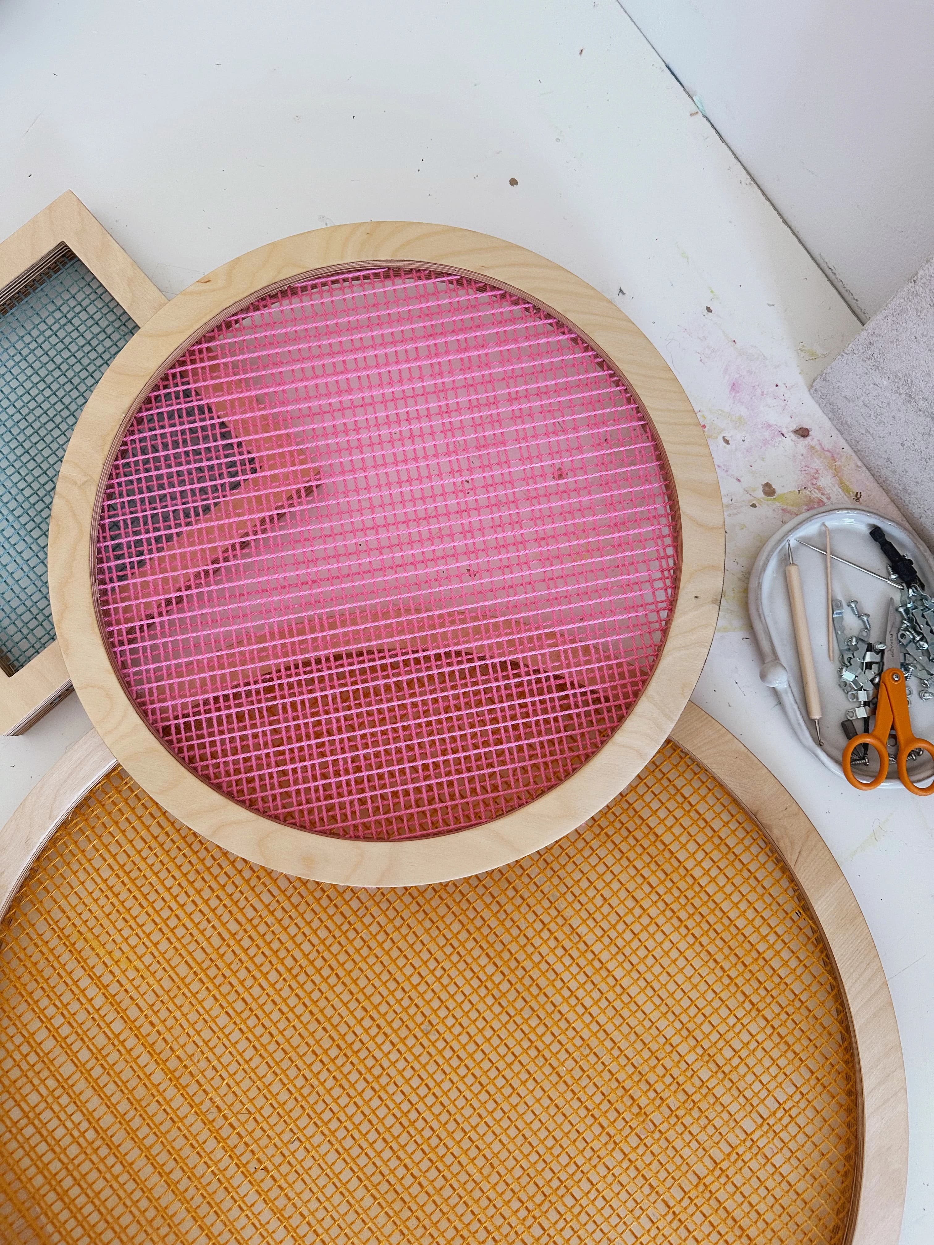 Circular shaped screens, one hot pink and one orange, by artist Hayley Sheldon.