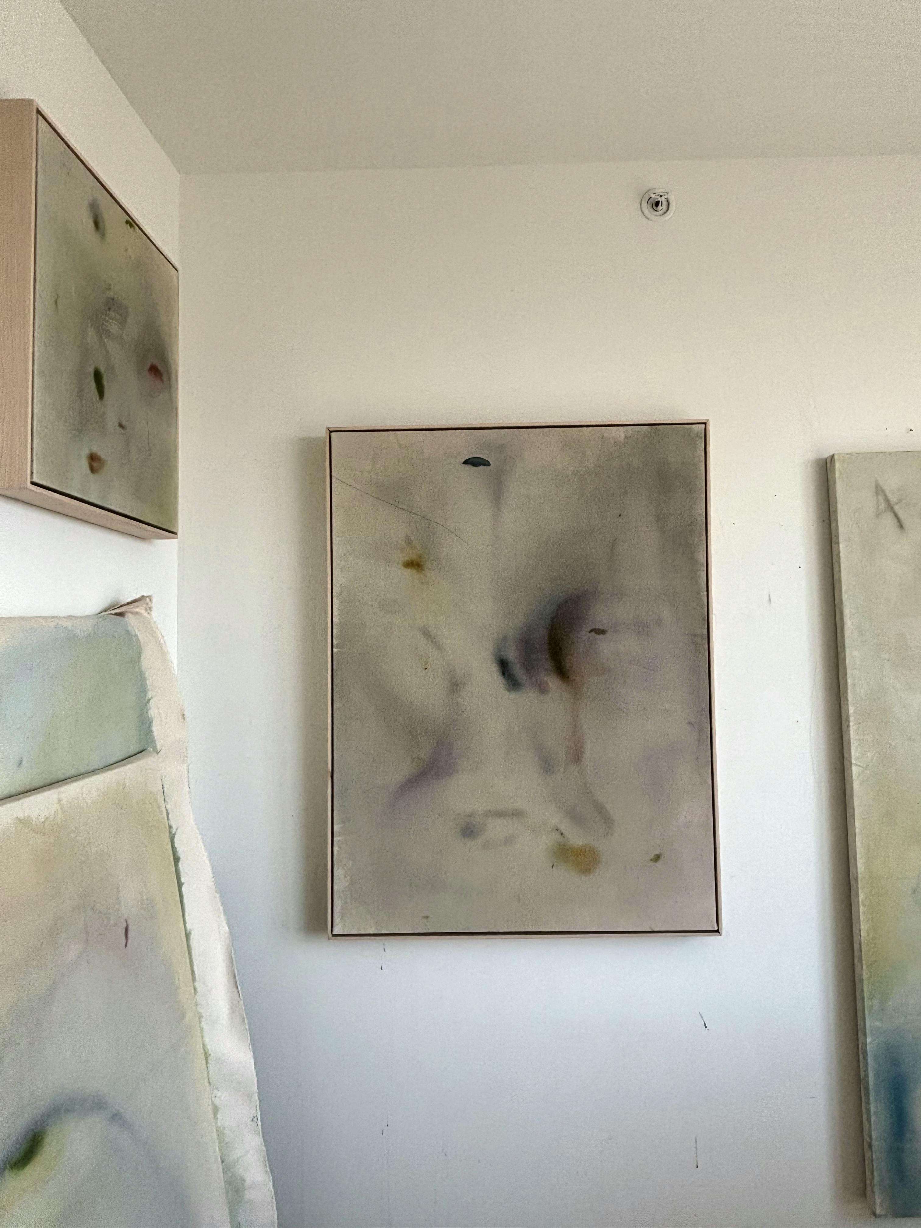 Soft abstract paintings installed on a white walls in artist Arlina Cai's studio.