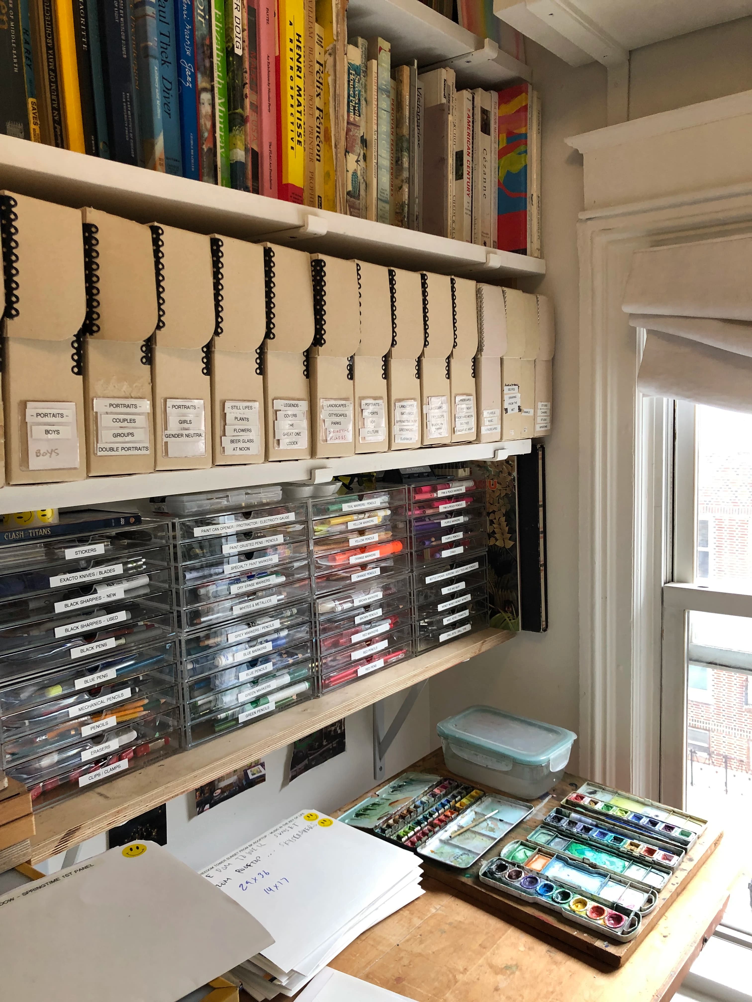 Artist David Rhoads' organized artist studio filled with labeled binders and clear plastic drawers.