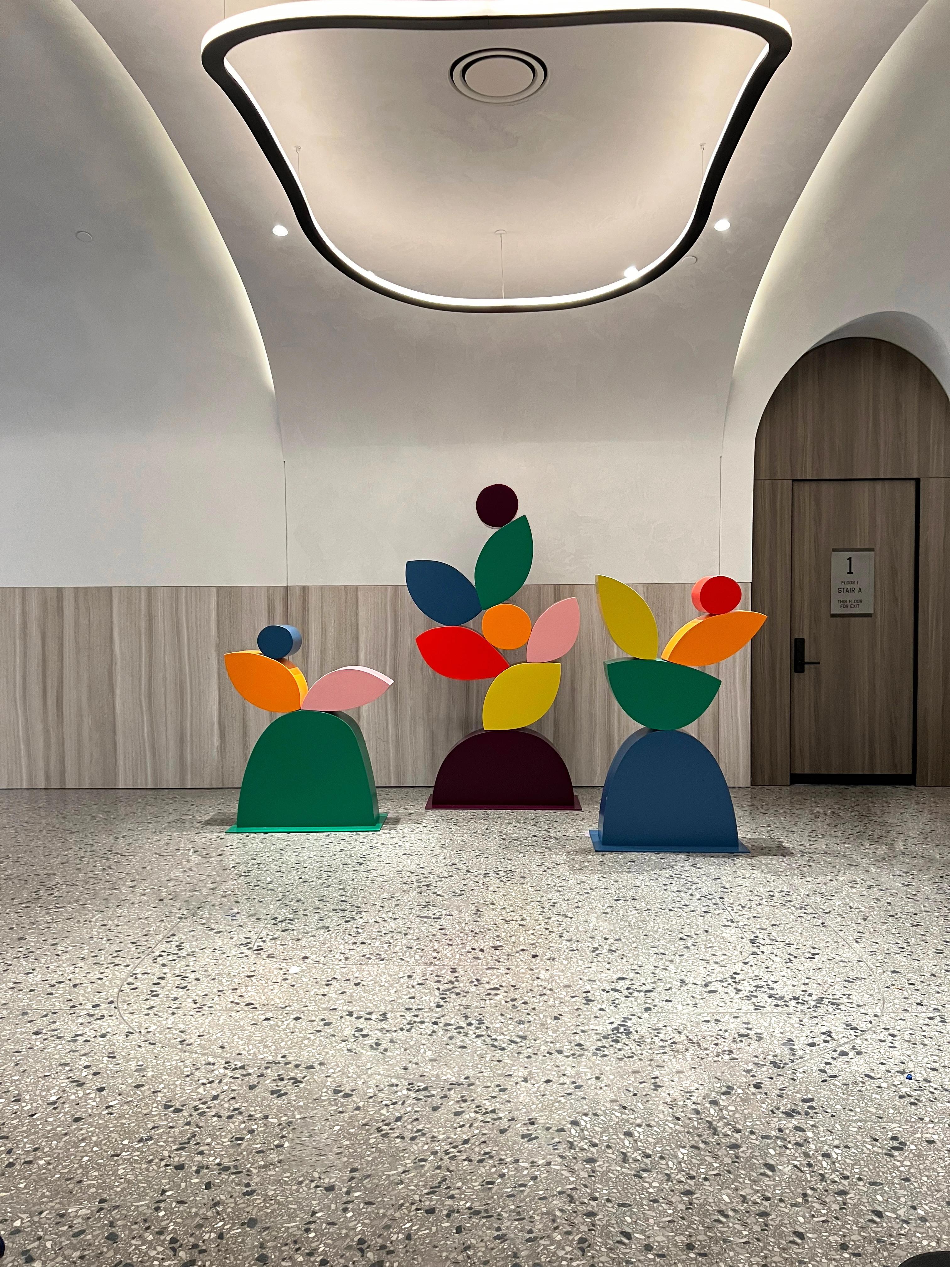 Three, free-standing colorful sculptures by artist Vicki Sher in a lobby at the Suffolk.