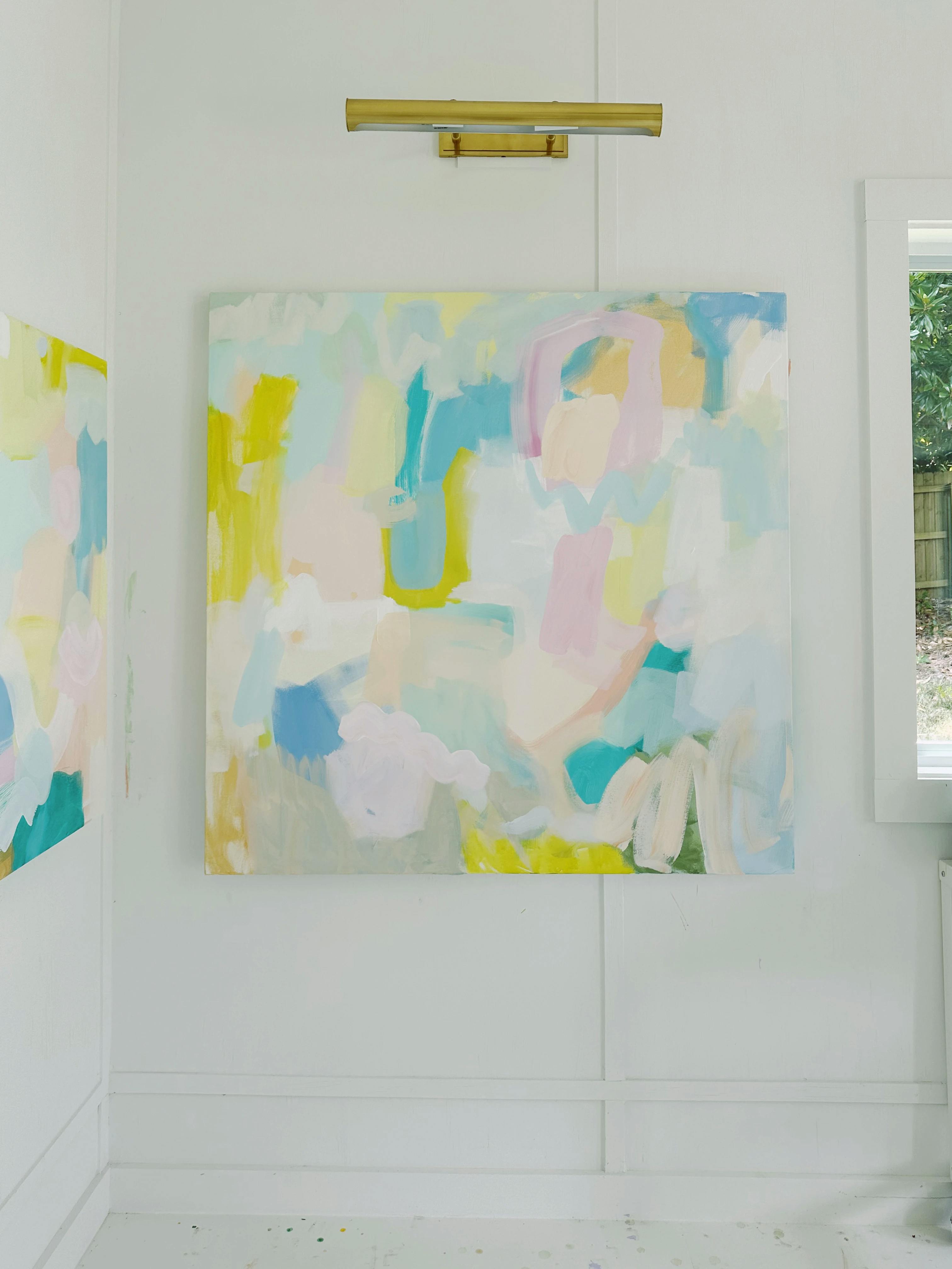 An abstract, pastel-colored painting installed on a white wall in artist Britt Bass' studio.