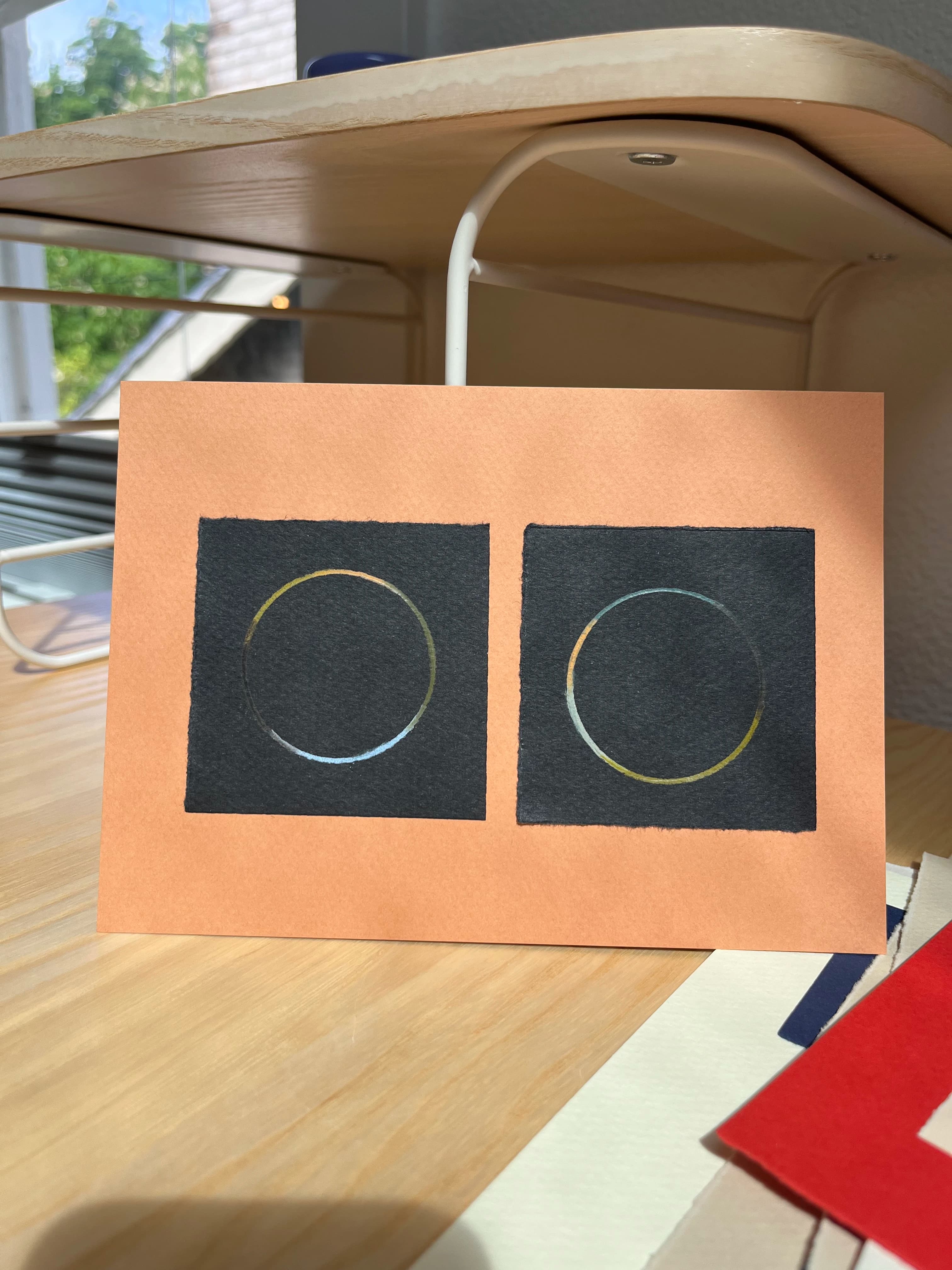 A minimalist, orange and black work on paper with two circles by artist Chloe Fields.