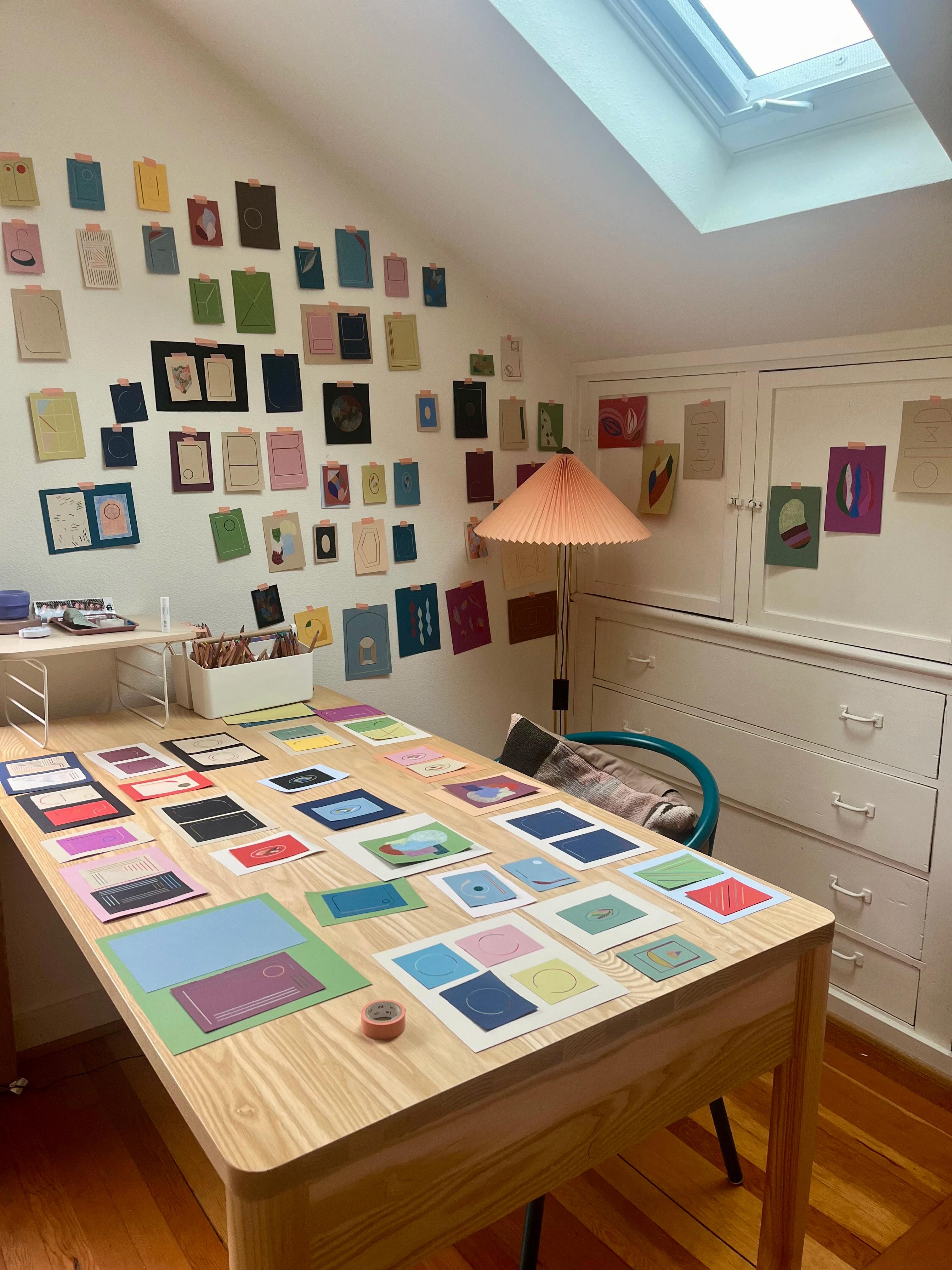 Artist Chloe Fields' studio filled with small, colorful works of art installed on the walls.