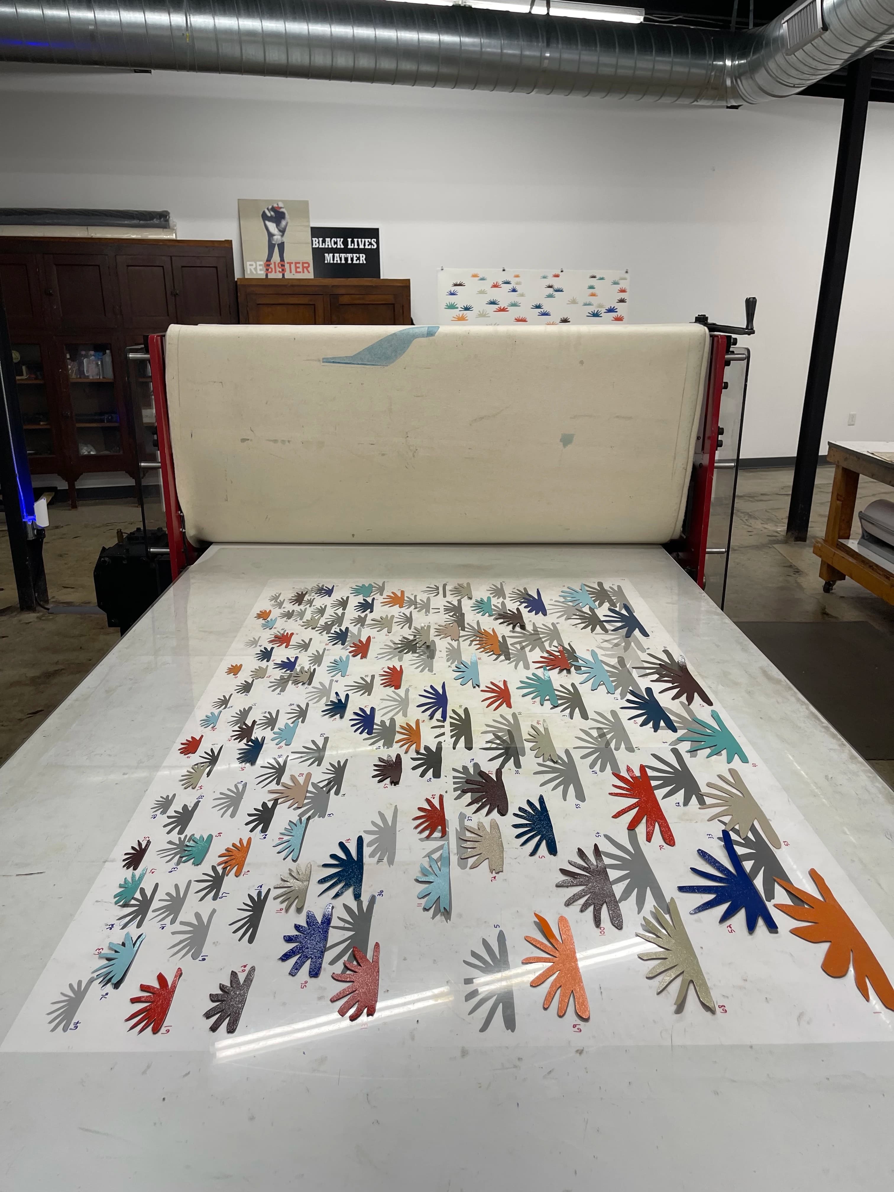 A large monoprint with abstract botanical forms on a printing press in artist Laura Berman's studio.