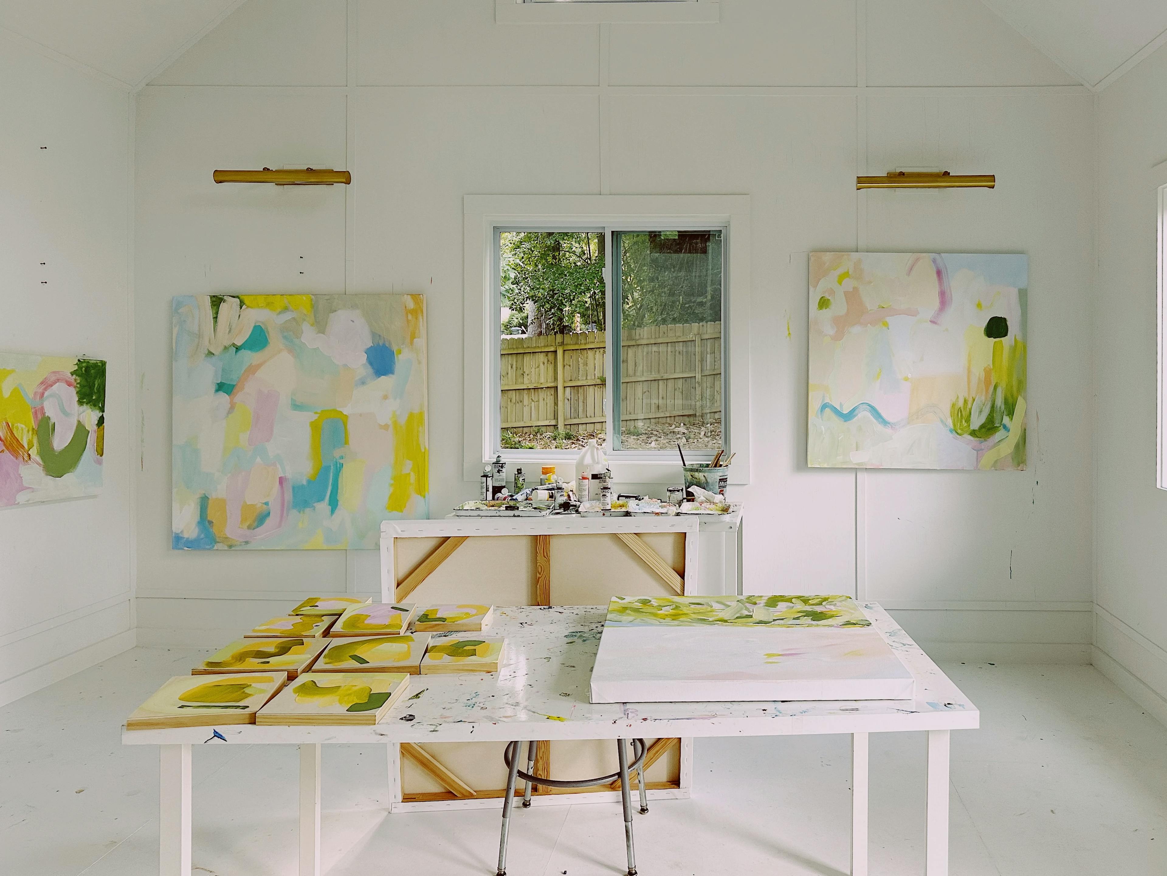 Abstract, pastel-colored patchwork paintings in artist Britt Bass's white studio.