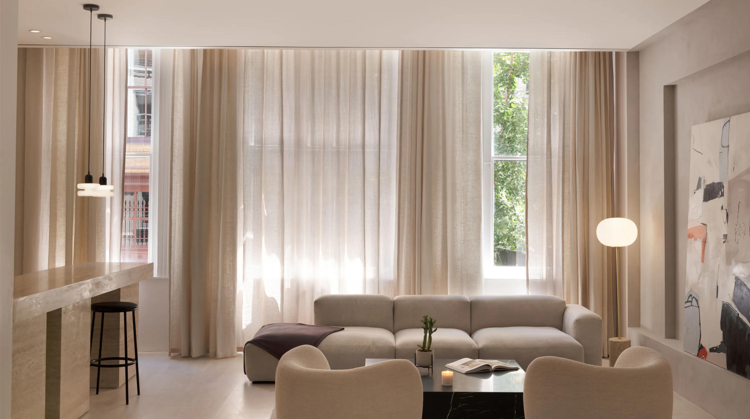 Lounge area with neutral curtains and sofas at the Thuma NYC Flagship.