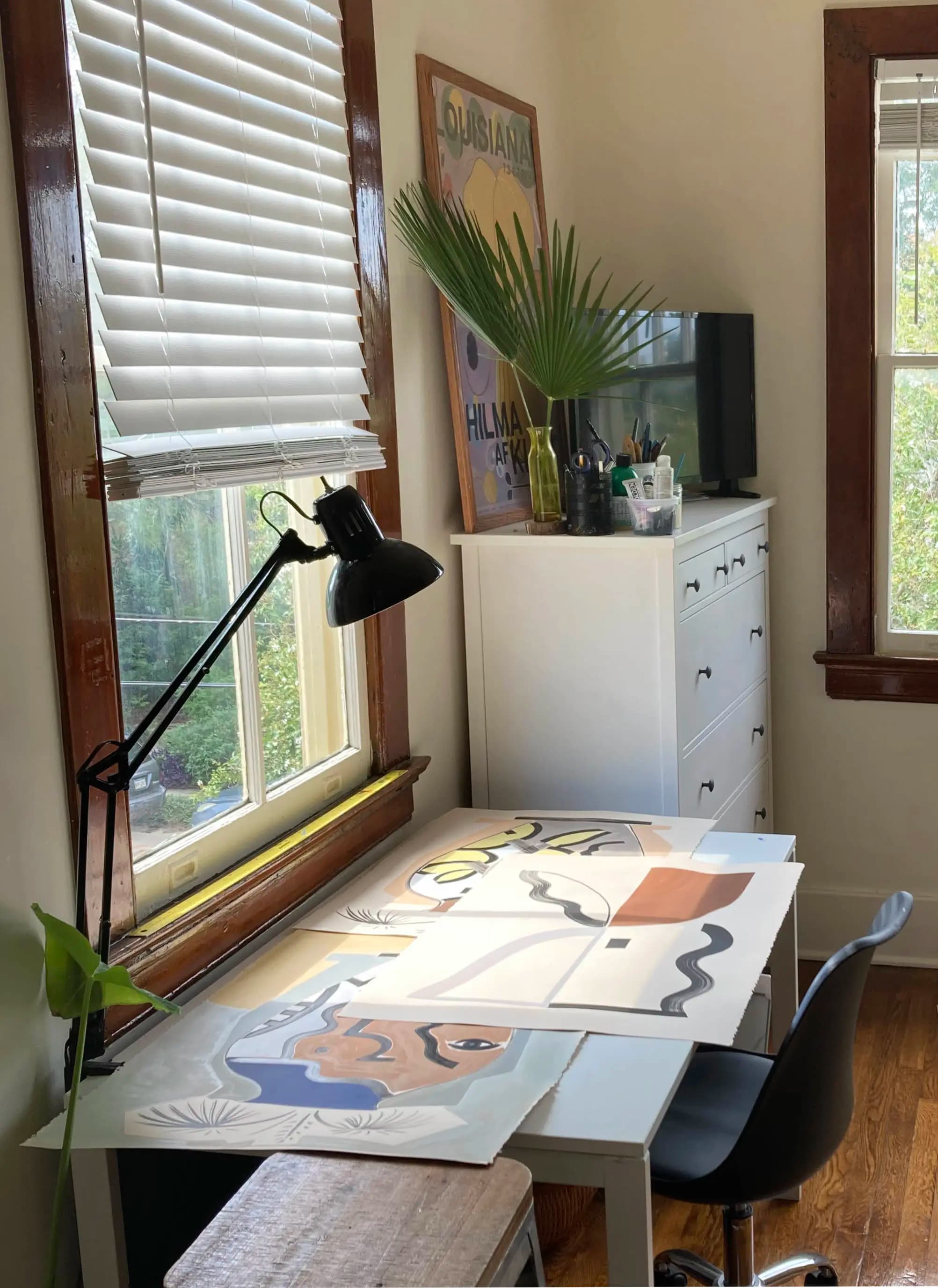 Works on paper on a desk next to a sunny window in artist Anna Koeferl's studio.